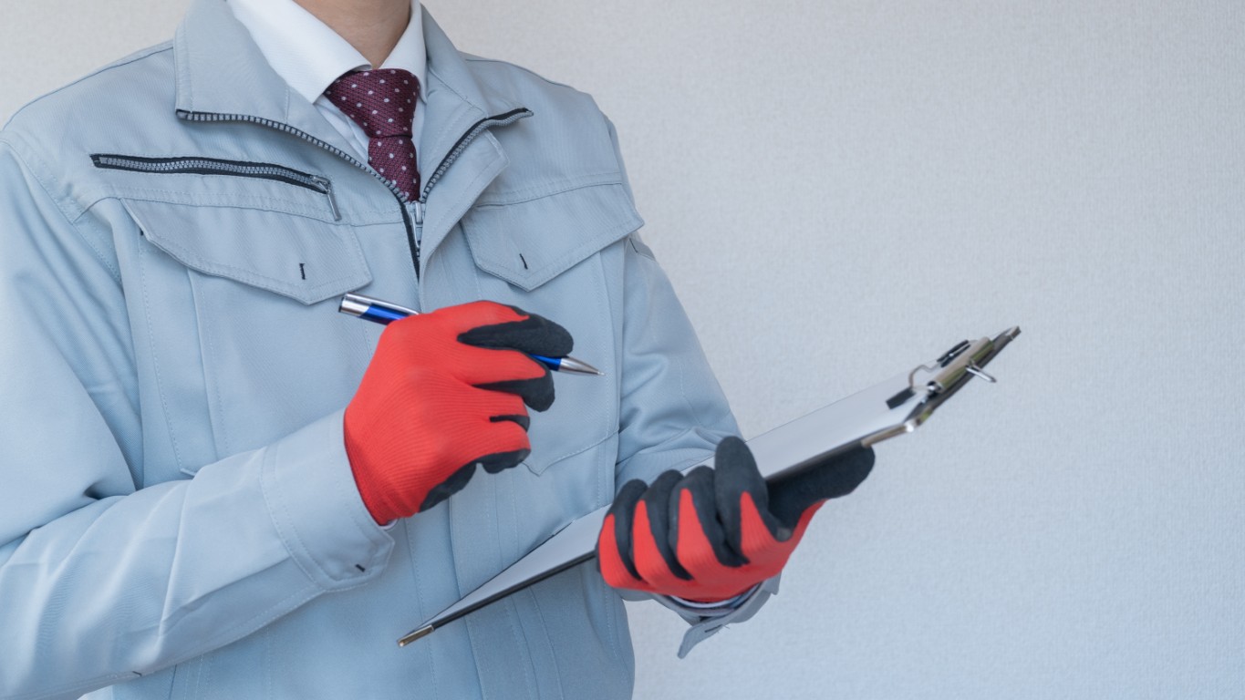 クリップボードを持つ作業服の男性｜建設業・